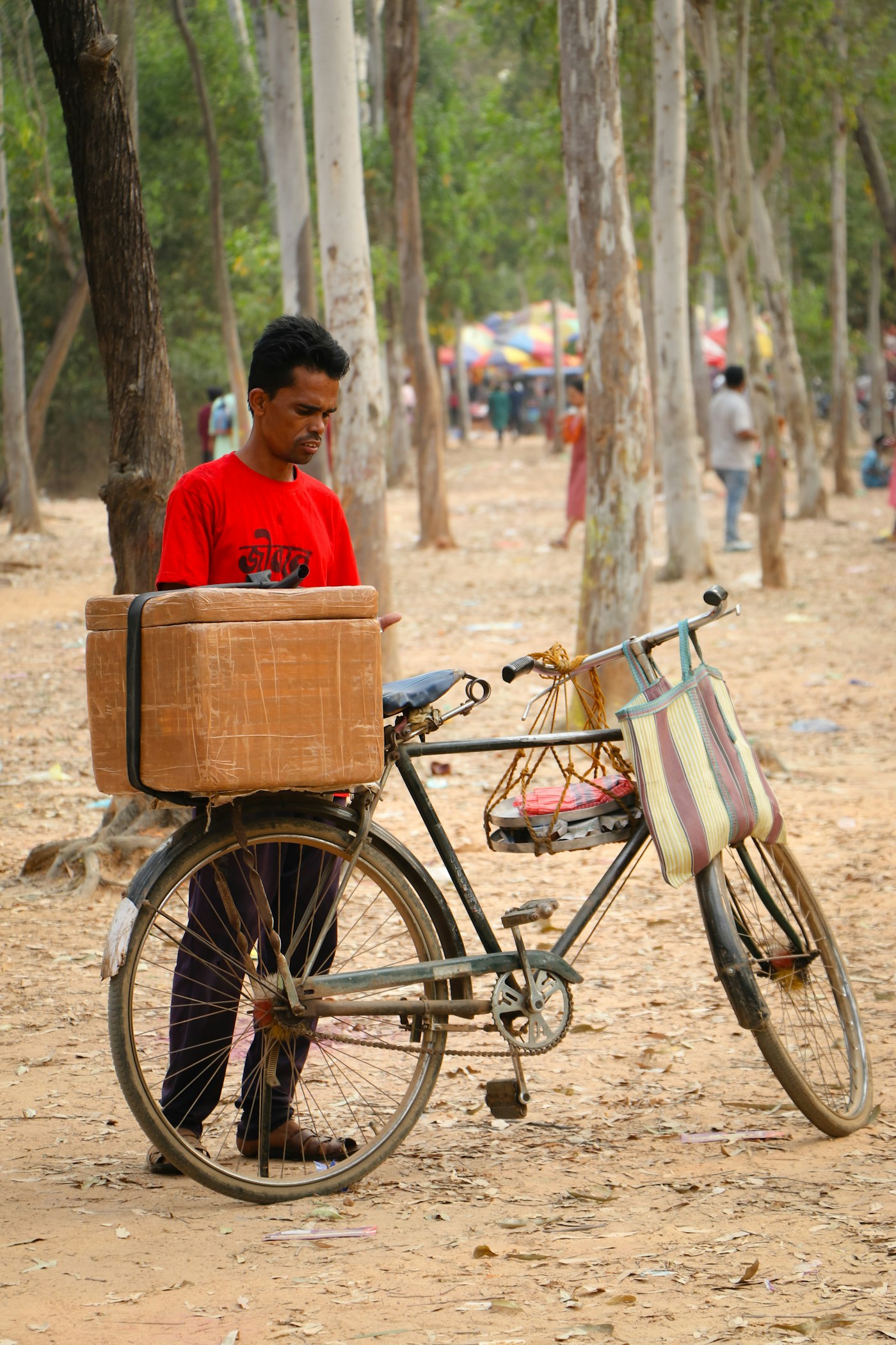 Delivery man with a parcel beside his bicycle